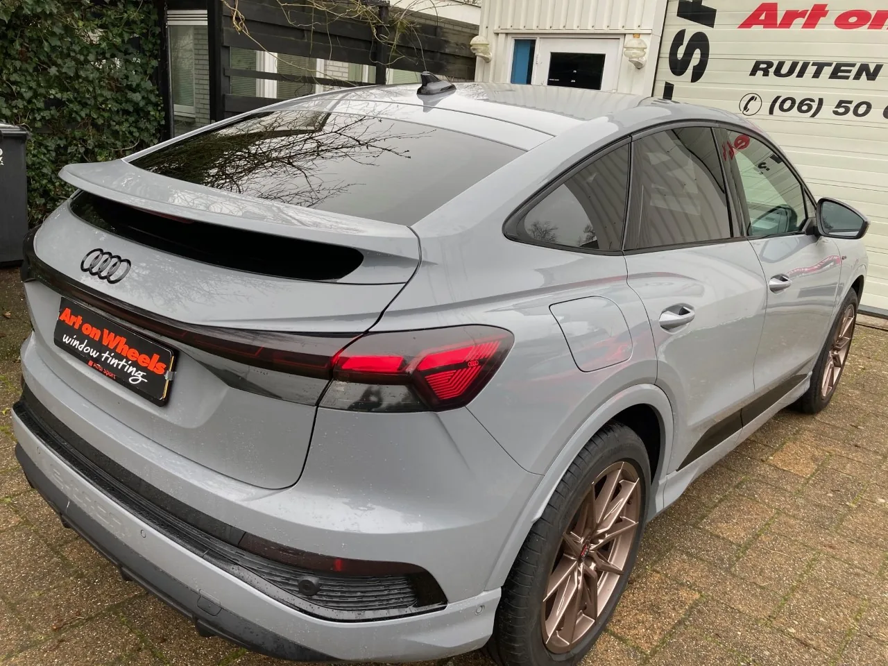 Grijze Audi Q4 Sportback met getinte ruiten voor de tintshop in Schagen