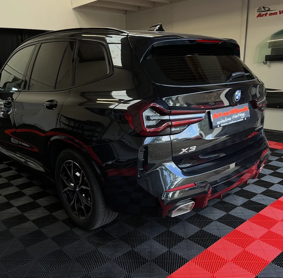 Zwarte BMW X3 met getinte ruiten in de showroom
