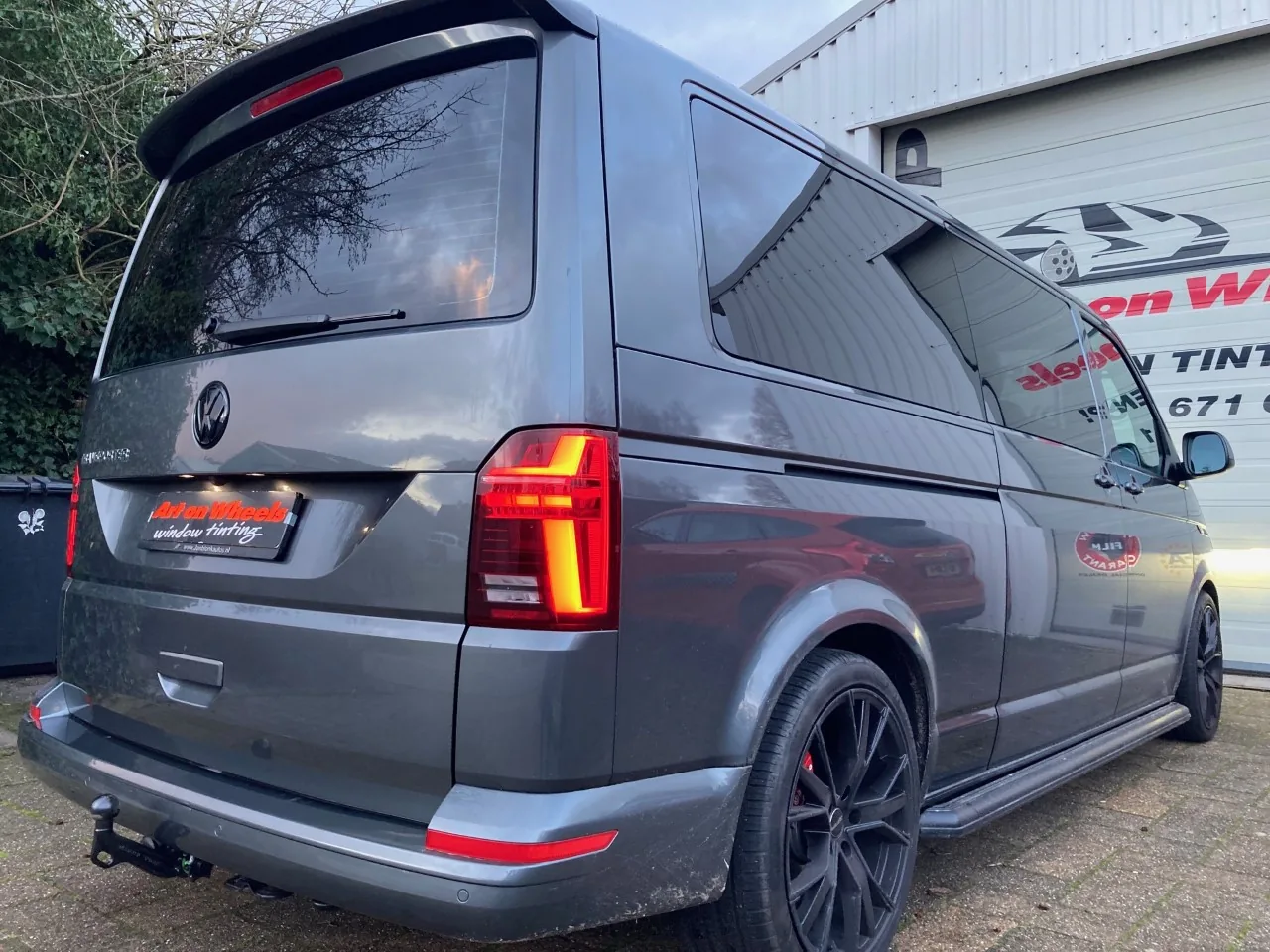 Grijze Volkswagen Transporter met getinte zijruiten voor de tintshop in Schagen