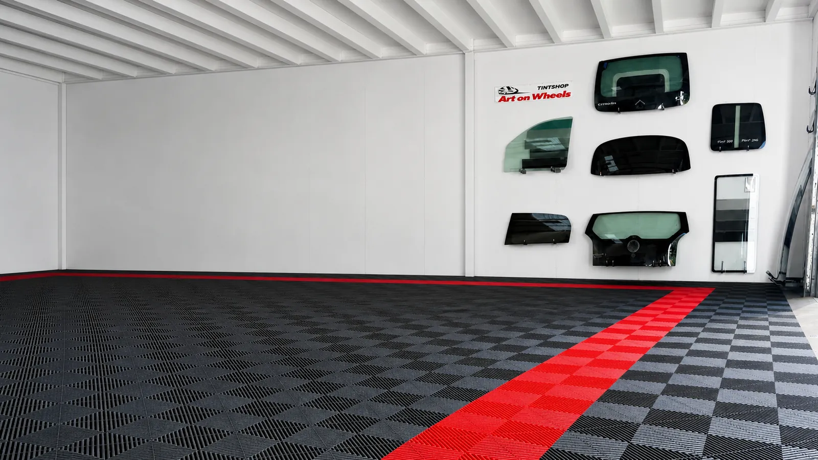 Showroom van Art on Wheels in Schagen met zwarte tegelvloer en rode baan